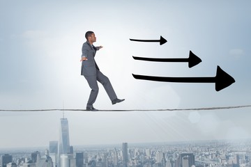 Composite image of businessman performing a balancing act