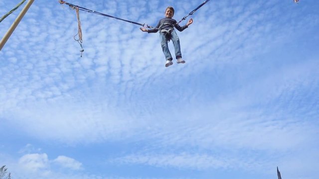 Boy jumping on bungee trampoline