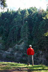 Obraz premium Man hiker in waterproof jacket admiring the cliff