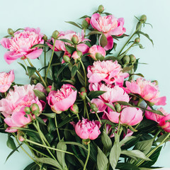 Beautiful pink peonies flowers bouquet on pale blue background. Flat lay, top view flowers pattern.