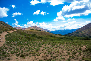 Mountain trail, green meadow and distant mountains, Colorado. USA
