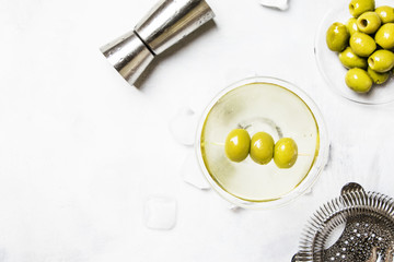 Dry martini cocktail with olives, gray background, top view