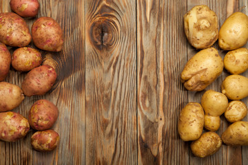 Raw potatoes on a wooden background