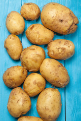 Raw potatoes on a blue wooden background