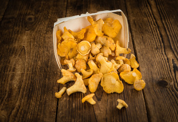 Portion of Chanterelles on wooden background, selective focus