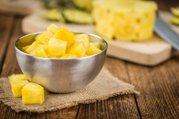 Portion of Pineapple (sliced) on wooden background, selective focus