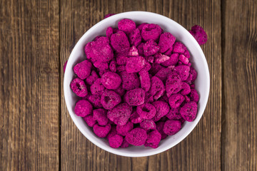 Portion of Raspberries (dried) on wooden background, selective focus