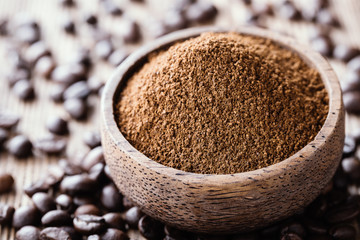 Ground coffee in a wooden bowl close-up.