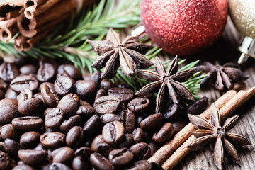 Coffee beans with cinnamon stick, aniseeds, fir-tree branch on wooden background