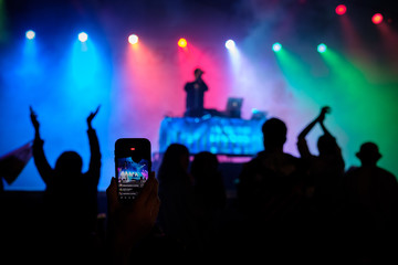 Fototapeta na wymiar A night concert with lights as seen through a cell phone screen