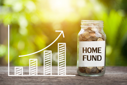 Home fund Word With Coin In Glass Jar and graph up. Financial Concept