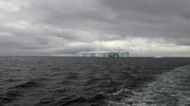 Arch of Darwin unique glacier iceberg in ocean of Antarctica. Amazing beautiful wilderness nature and landscape of white mountains. Extreme tourism cold desert north pole.