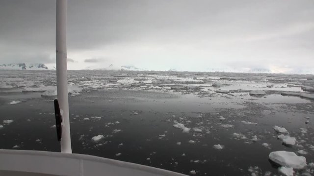 Ice movement and snow coastline view from ship in ocean of Antarctica. Amazing unique beautiful wilderness nature and landscape of white mountains. Extreme tourism cold desert north pole.
