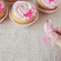 holding pink ribbon with Rose flower cupcakes for pink ribbon day, Breast cancer awareness