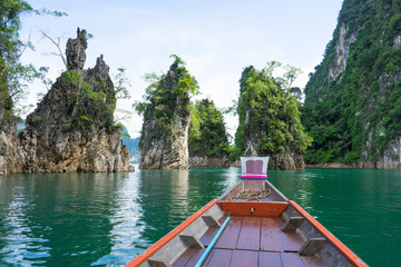 Fototapeta premium Boat tail to sail see scenic and unique landscape with floating houses and long tail boats at Chieou Laan lake, Thailand