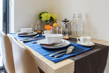 wooden table in dining room with elegant table setting