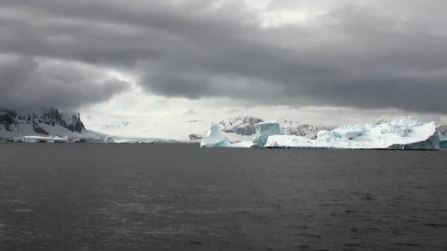 Huge unique glacier iceberg in ocean of Antarctica. Amazing beautiful wilderness nature and landscape of white mountains. Extreme tourism cold desert north pole.