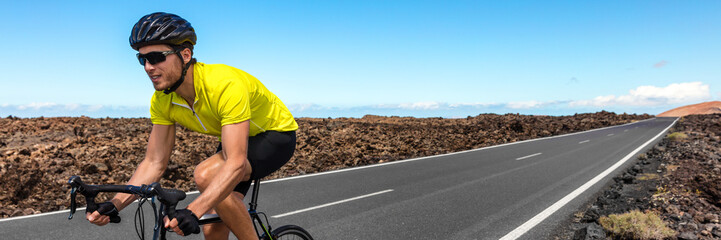 Road biking cyclist man training on bike panorama. Professional cycling athlete riding racing...