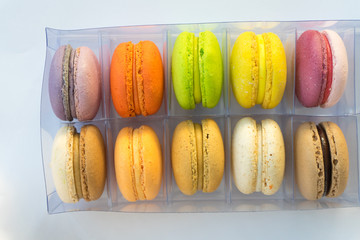 Set of different french cookies macaroons macaroons in a plastic box. Top view.