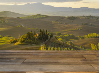 Fototapeta premium Drewniany stół,w tle klasyczny toskański krajobraz