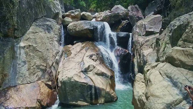 Drone Shows Cold Blue Lake on Foamy Waterfall Foot