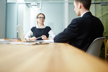 Employer talking to young applicant in office and discussing his skills