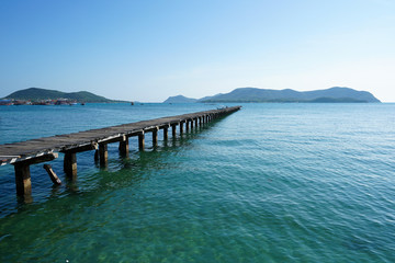 Fototapeta na wymiar Wooden bridge into the sea. Property is located at the end of the runway into the sea