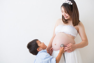聴診器で心音を聞く男の子と妊婦さん