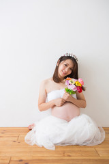 花束を持つドレスを着た妊婦さん