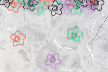 Scattered colored paper clips in form of star on old gray cement