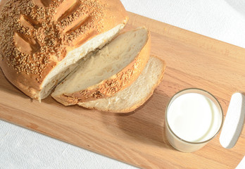 Homemade bread, sliced on a wooden board with milk