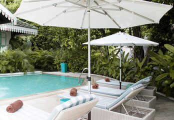 Atmosphere of the outdoor swimming pool. Beach chairs and umbrellas by the pool.