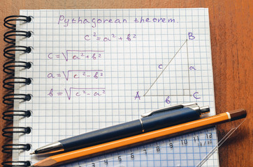 Page with formulas and the Pythagorean theorem with pen and pencil