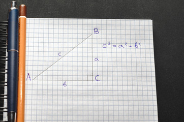 Page with formulas and the Pythagorean theorem with pen and pencil