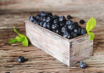 fresh blueberries and blueberry in a wooden box, selective focus