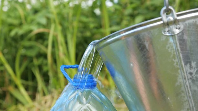 Pouring clean water into the plastic bottle