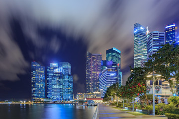 Landscape of the Singapore financial district and business building Singapore City, View from the infinity pool at Marina Bay Sands under moving clouds in blue sky at night