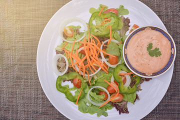 Top View Fresh mixed vegetable salad on plate, light effect.