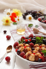 Biscuit with fresh berries on white plate. Selective focus.