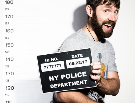 bearded man in handcuffs holds a sign, Criminal Mug Shots