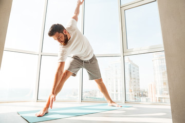Fototapeta premium Bearded man warming up over window background