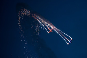 Two planes on the sky during the night airshow. - obrazy, fototapety, plakaty