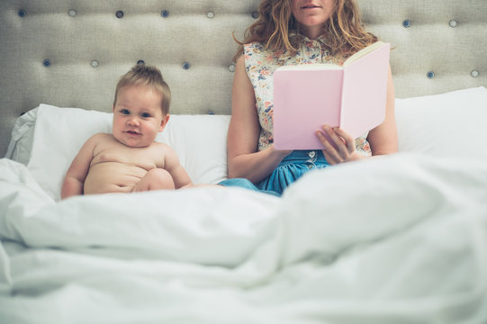 Mother in bed reading to her baby