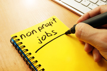 Man is writing non profit jobs in a note.