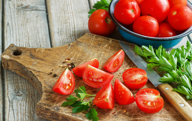 red tomatoes on a wooden board with parsley. country style