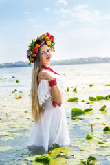 Fototapeta na wymiar girl in the middle of a lake with flowering water lilies, summer