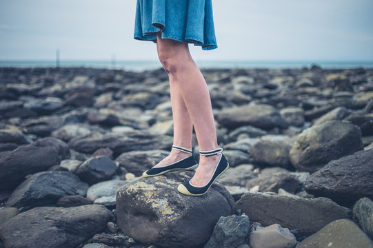 Feet and legs of young woman on beach in autumn