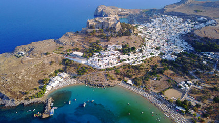 Aerial drone photo of famous beach of Lindos with turquoise waters and iconic ancient Acropolis -...