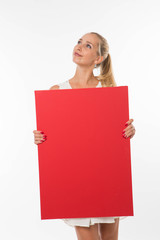 Young pensive woman portrait of a confident businesswoman showing presentation, pointing placard gray background. Ideal for banners, registration forms, presentation, landings, presenting concept.