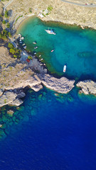 Aerial drone photo of famous beach of Lindos with turquoise waters and iconic ancient Acropolis - village of Lindos, Rodos island, Aegean, Dodecanese, Greece